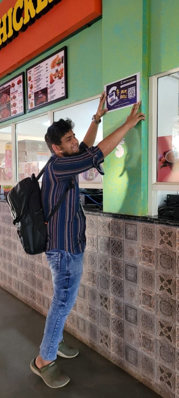 Putting up a BUY SELL brand poster on campus